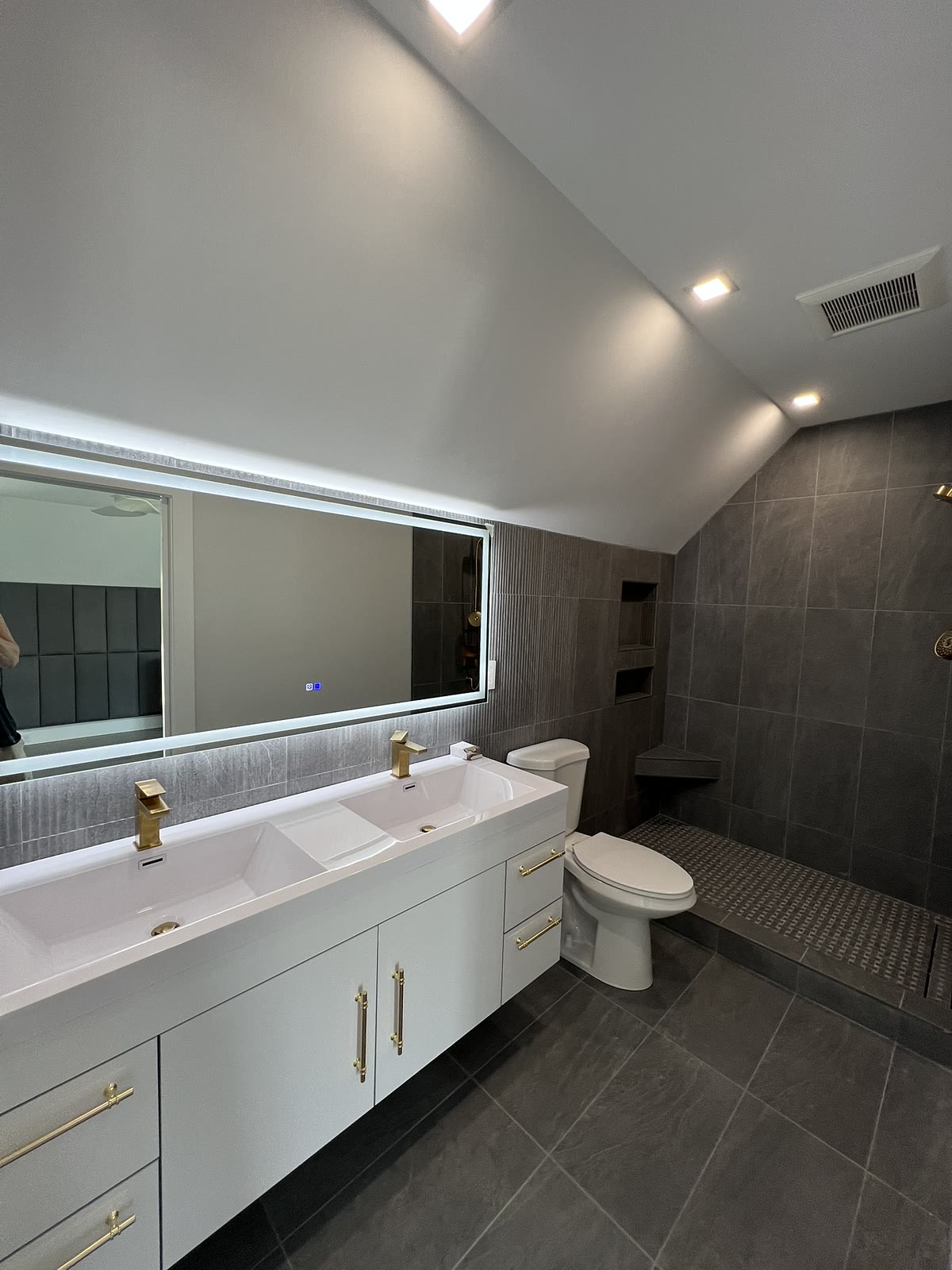 Modern master bathroom with floating double vanity and gold fixtures